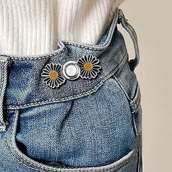 Daisy waist knots on denim jeans with mushroom pin for adjustable no-sew fit.